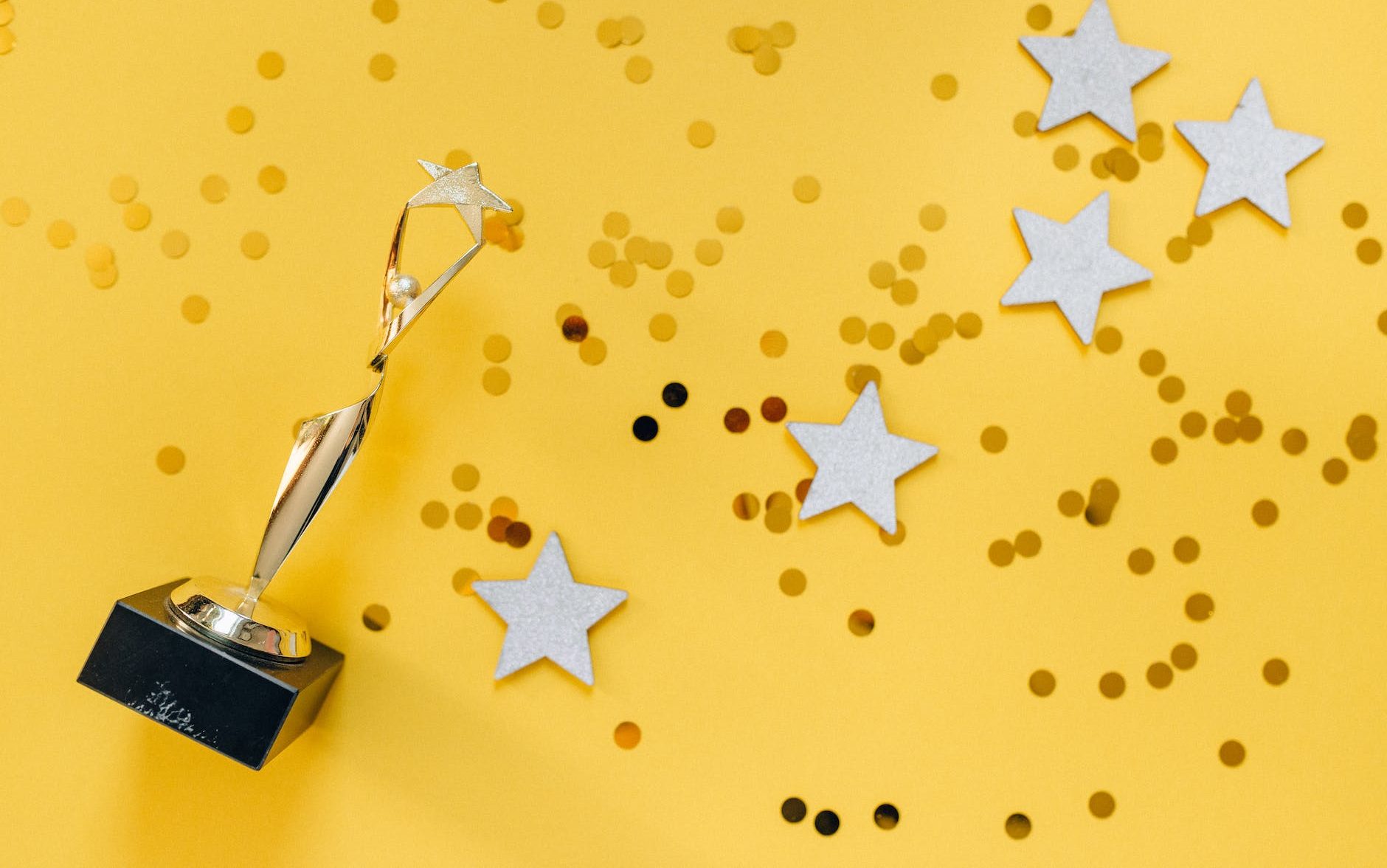 golden statuette and stars on yellow background